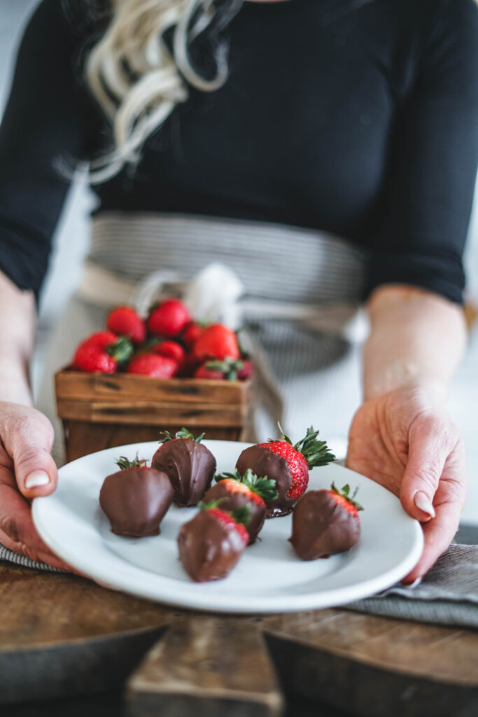 A plate full of dipped strawberries in dark chocolate.