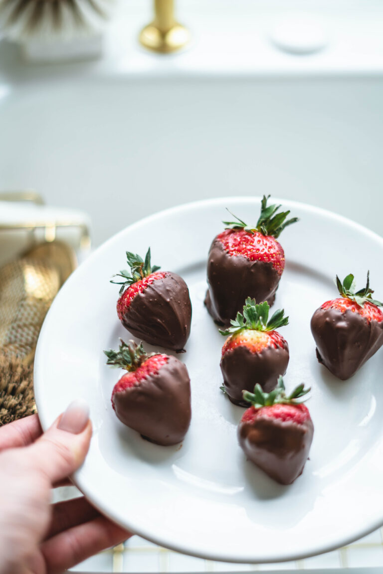 Delicious dark chocolate dipped strawberries on a white plate.