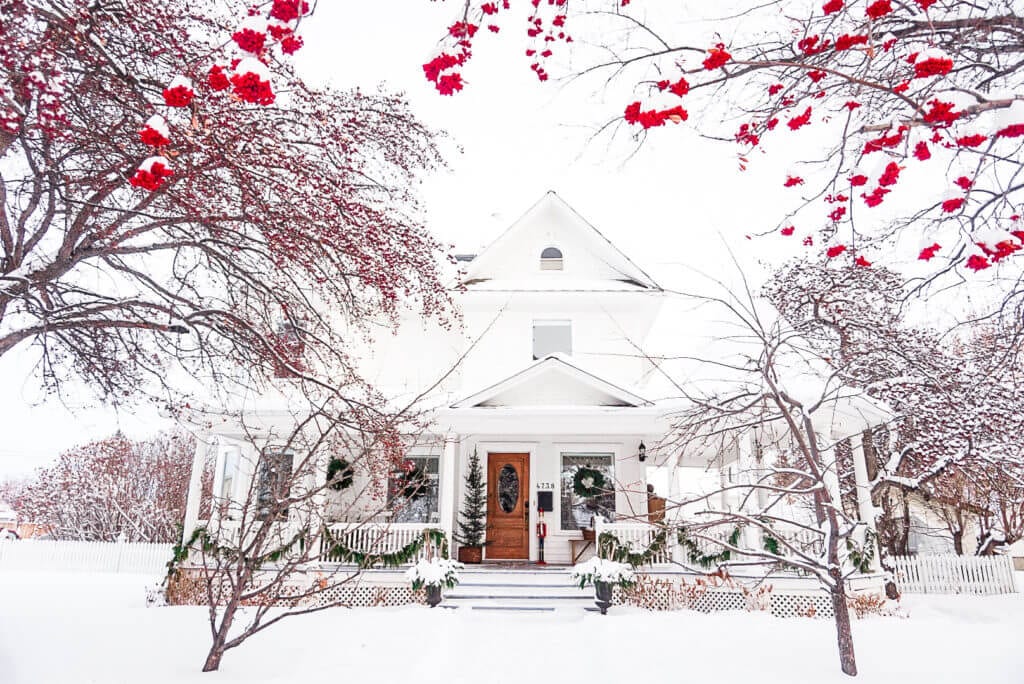 white victorian home decorated for the holidays with mountain ash berries