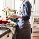 a girl cutting fresh roses at a farmhouse sink to make them last longer