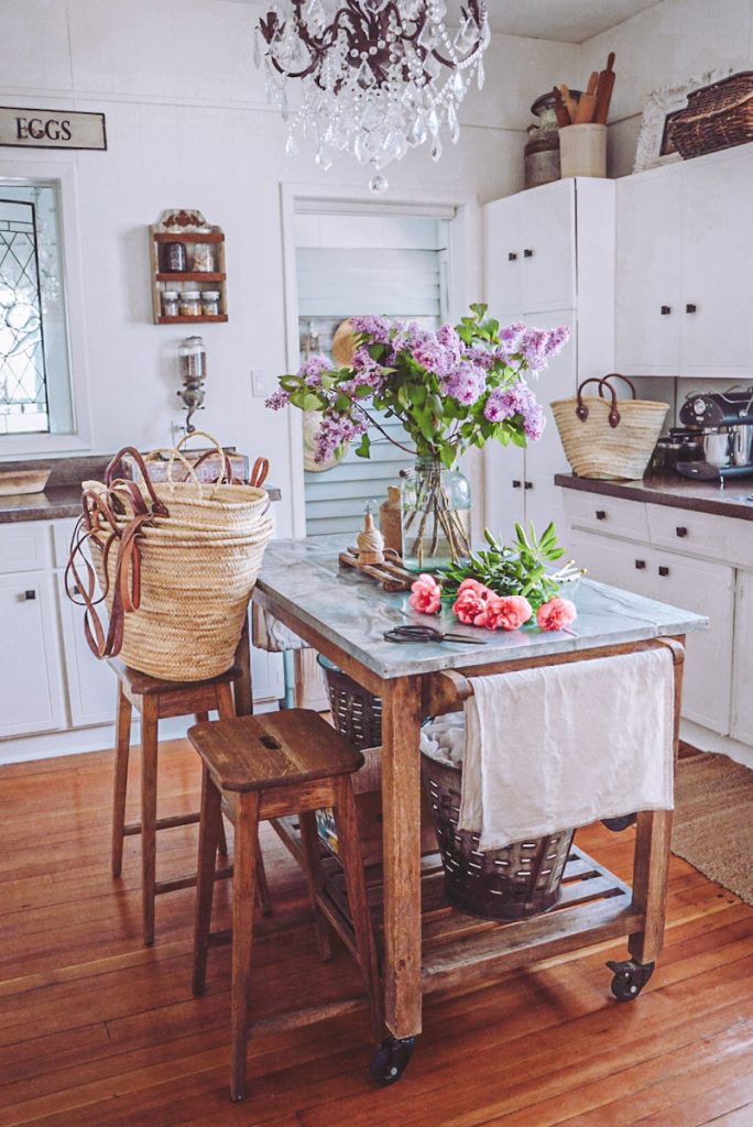Farmhouse kitchen with a chandelier and french market baskets used for storage and organziation.