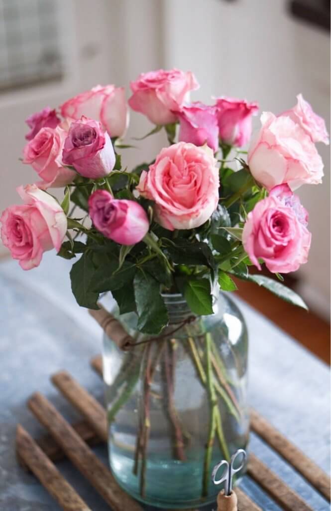 pink roses in a vintage mason jar in a farmhouse kitchen