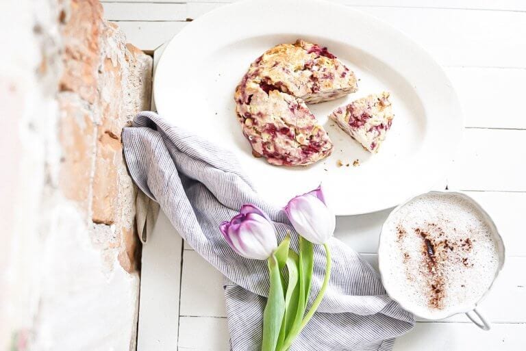 white chocolate raspberry scone with tulips and a brick wall