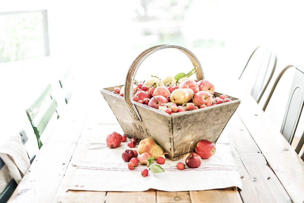 apples in a basket on a farmhouse table