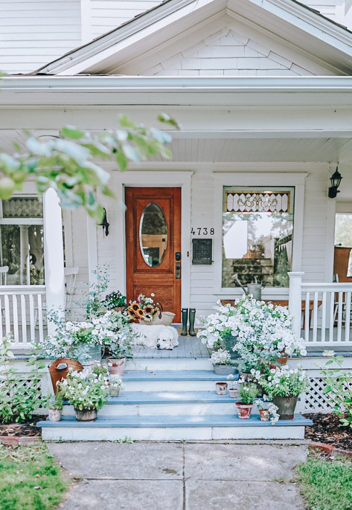 Beautiful front porch stairs covered in blooming flower pots