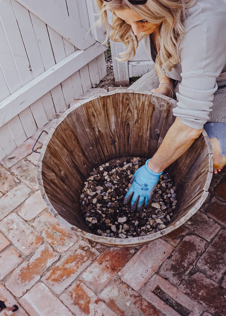adding a layer of rocks at the bottom of a flower pot for drainage