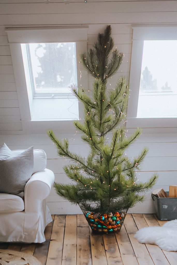Natural Pine Christmas tree with a vintage basket full of antique ornaments for a base