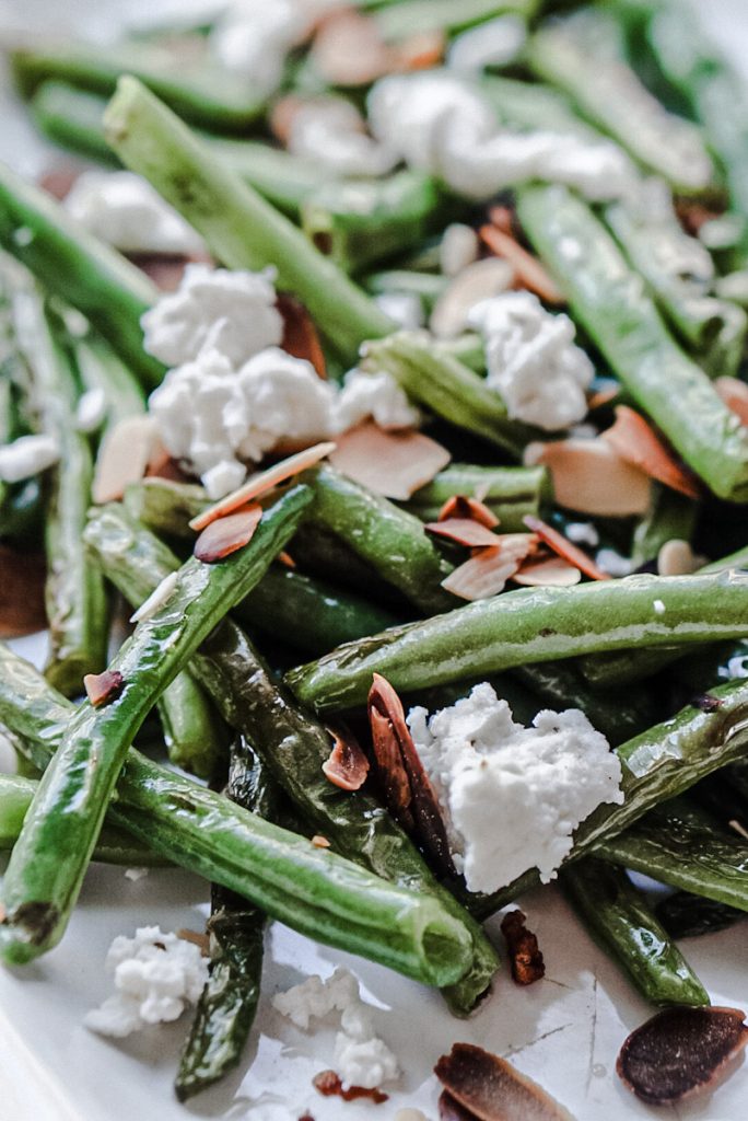 up close of a delicious green bean salad with goat cheese and toasted almonds