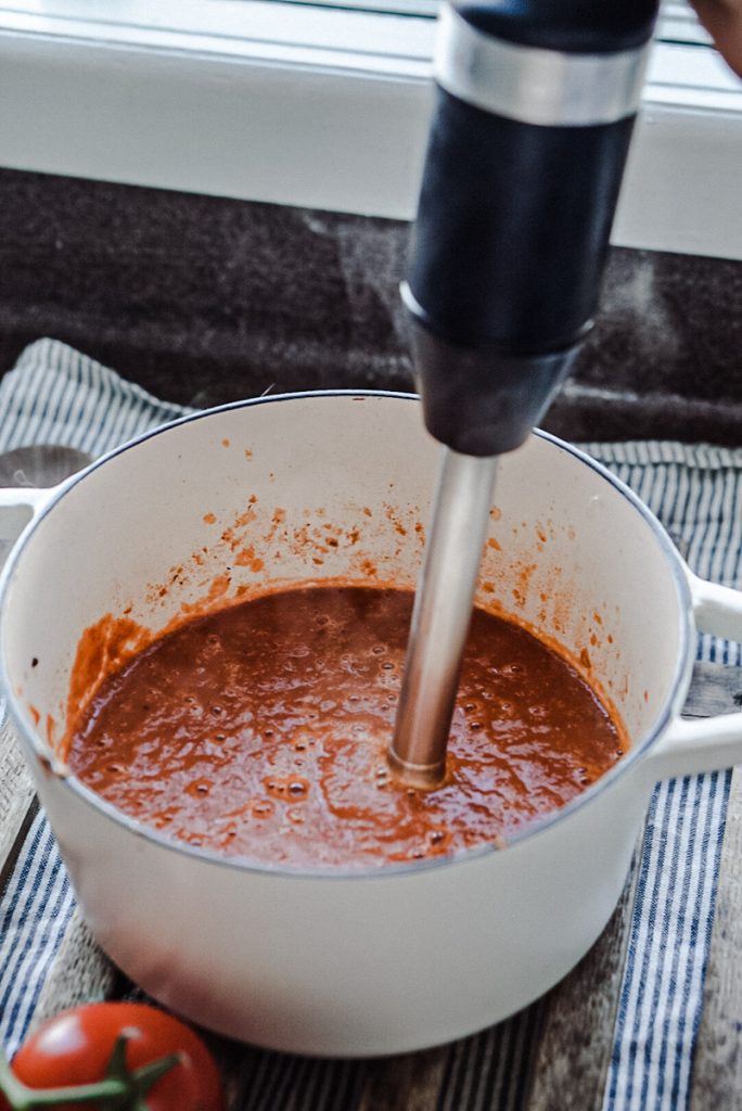 Pureeing a pot of smoked tomato soup.