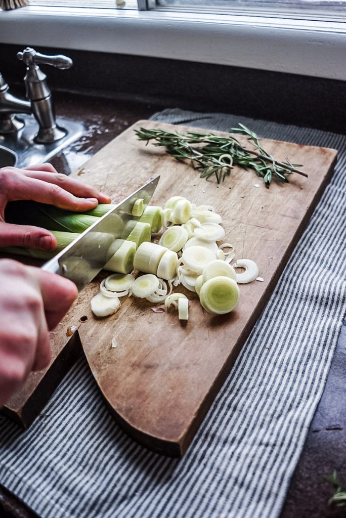 chopping up a leek to make braised chicken