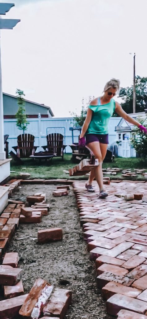 Carrying heavy reclaimed bricks to make a patio.