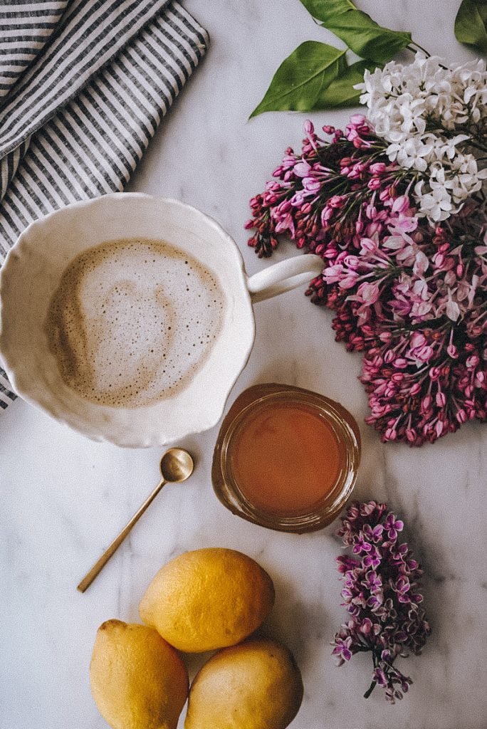 beautiful lilac blossoms beside a latte, simple lilac syrup and lemons