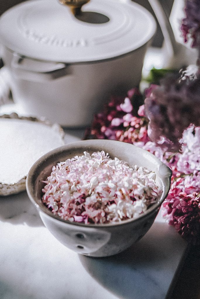 fresh lilac flowers in a berry strainer after being cleaned