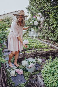 girl picking pick and white peonies in a garden