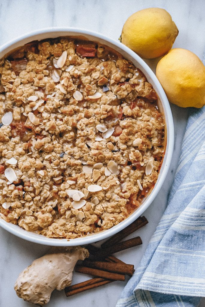 A fresh baked crumble that has almond slices on top and rhubarb and ginger for filling