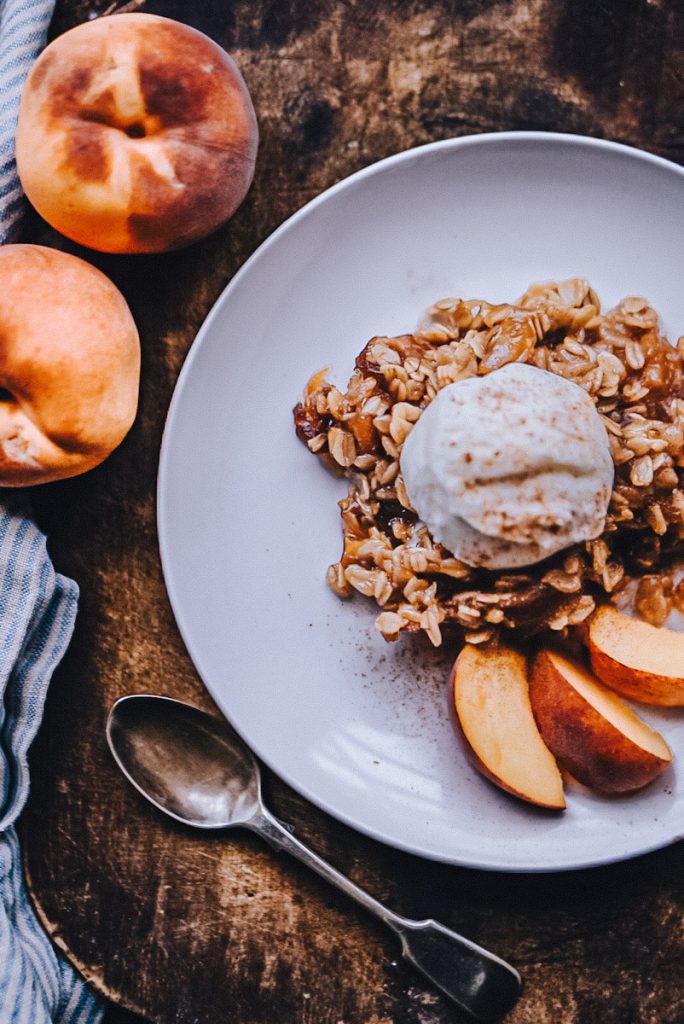 Peach crumble topped off with ice cream and spices.