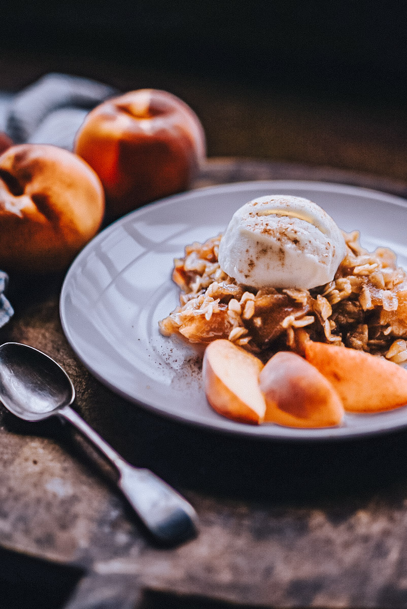 Peach crumble with oats and a scoop of ice cream.