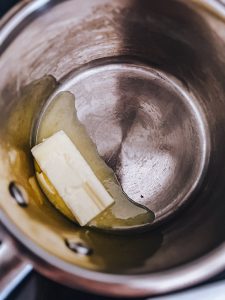 Melting butter in a pot to make béchamel from scratch on a stove.