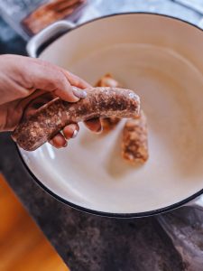 removing the casing from a sweet Italian sausage for making lasagna.