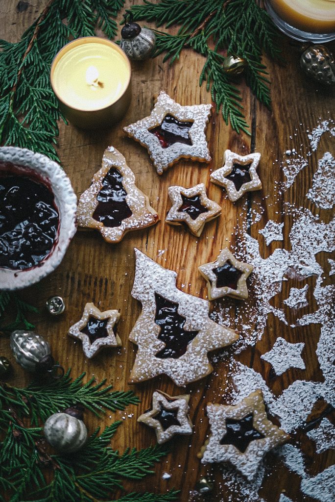 Beautiful and classic Linzer cookies on a cutting board with icing sugar dusted on top.