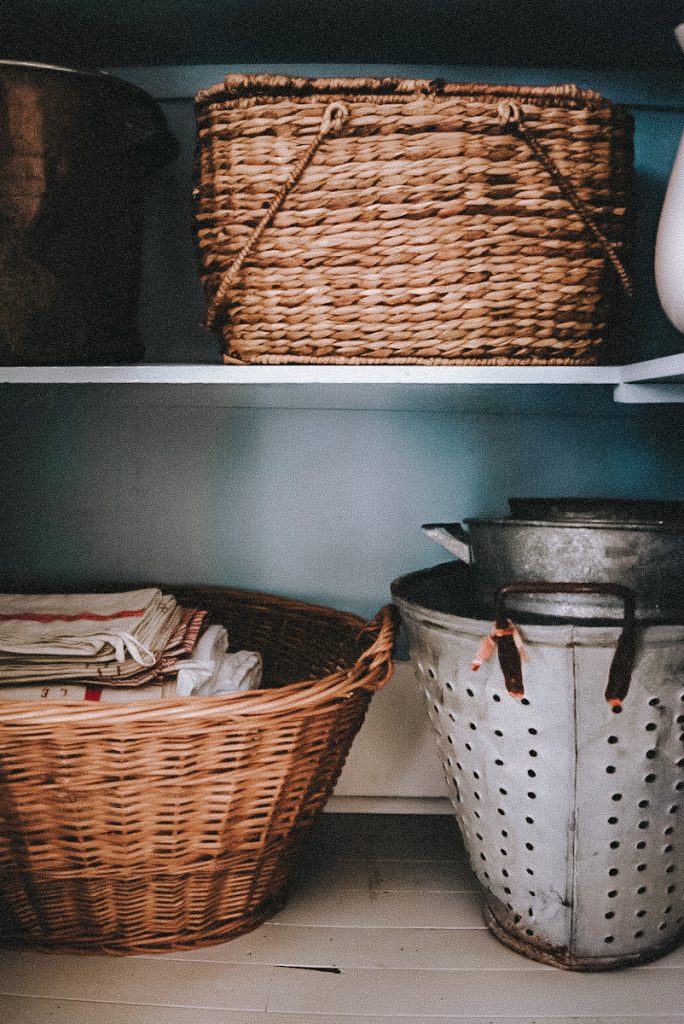 Baskets and containers being used for linen closet organization.