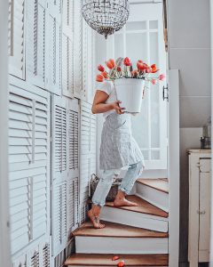 Deb from B Vintage Style walking up the stairs carrying a bucket full of tulips