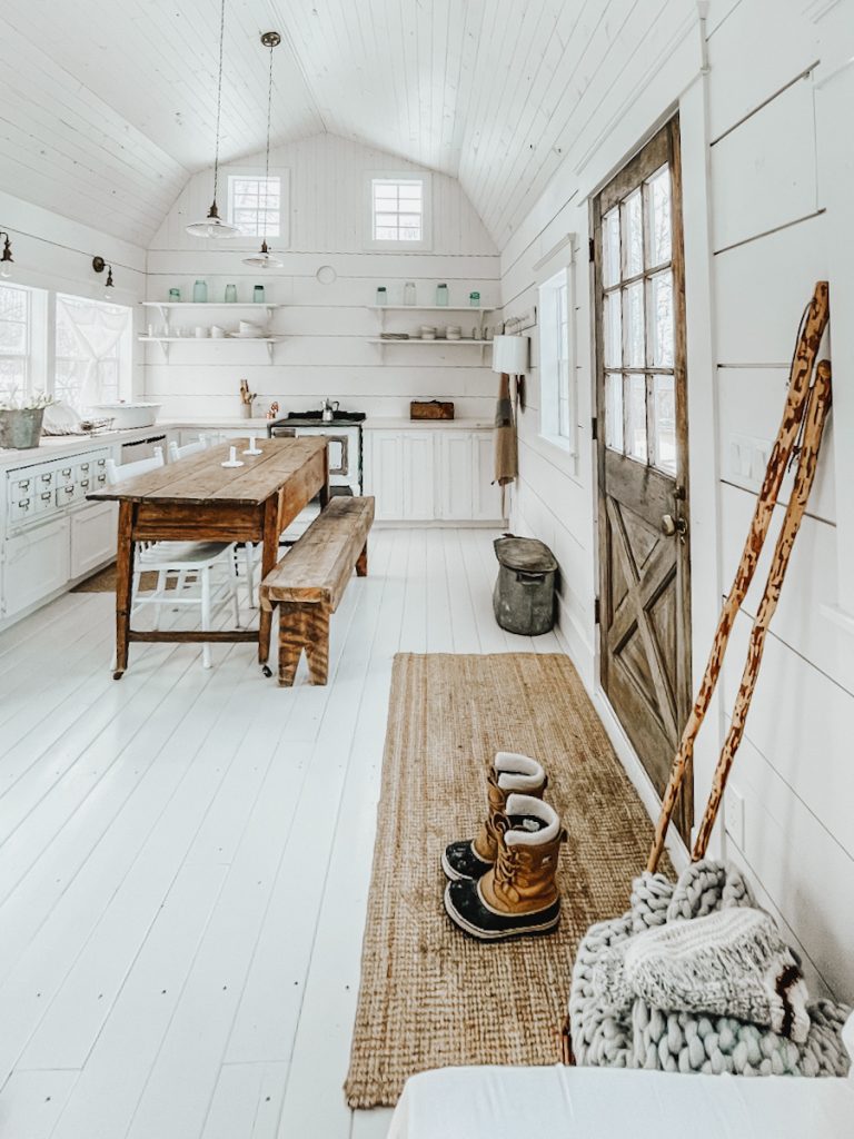 Scandinavian style cabin with shiplap walls, lots of wood accents, farmhouse decor, and antique furniture.