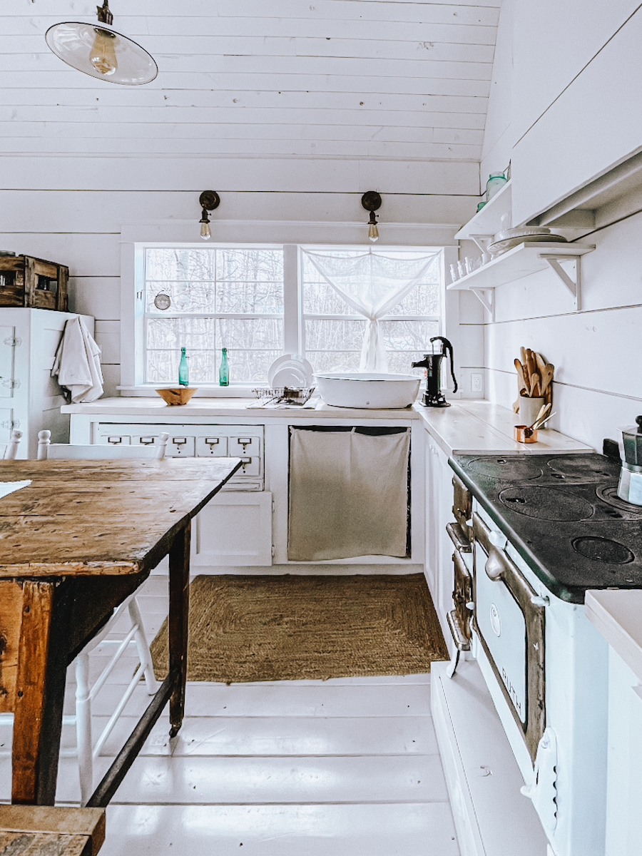 Beautiful white tiny house minimal kitchen that is very clutter free and organized.