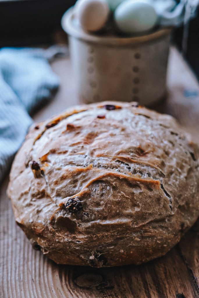 A beautiful loaf of no knead cinnamon raisin bread that has been baked using a Dutch oven.