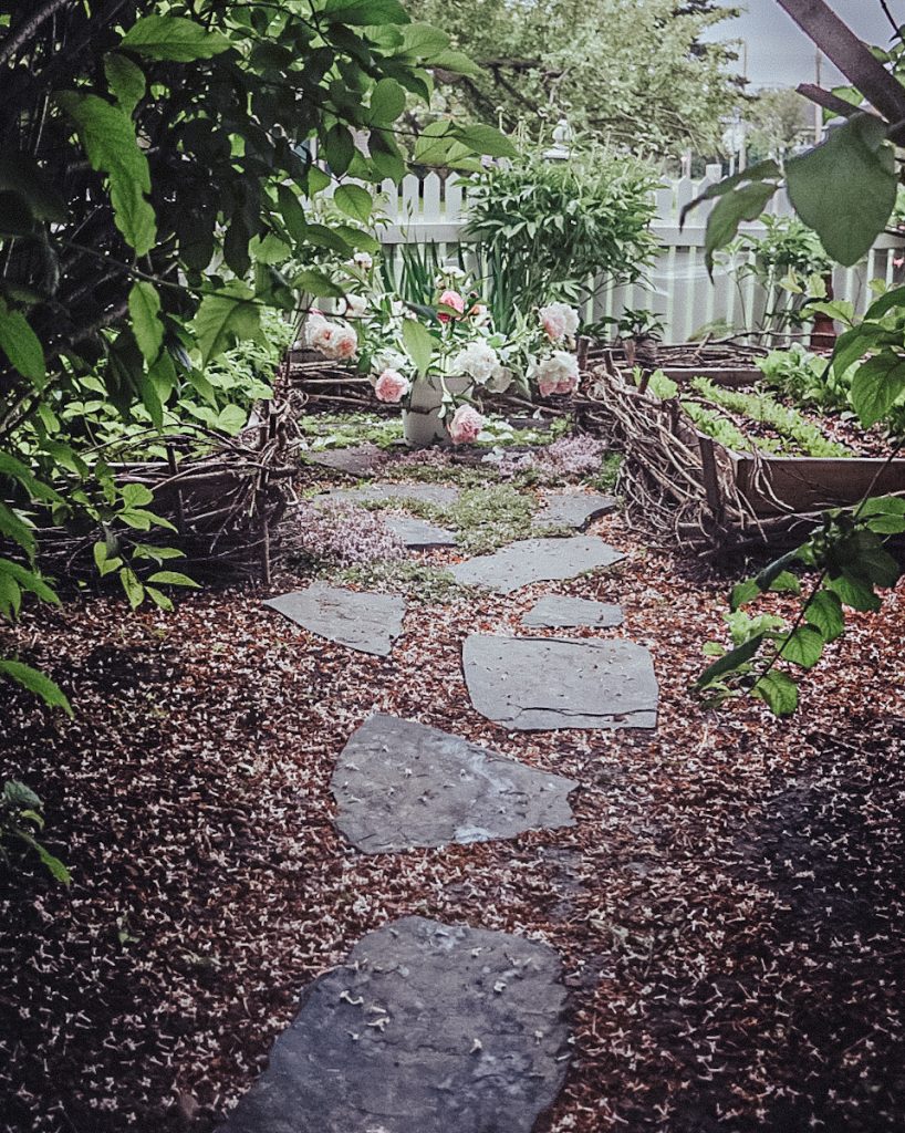 A stunning stone pathway into a beautiful garden.