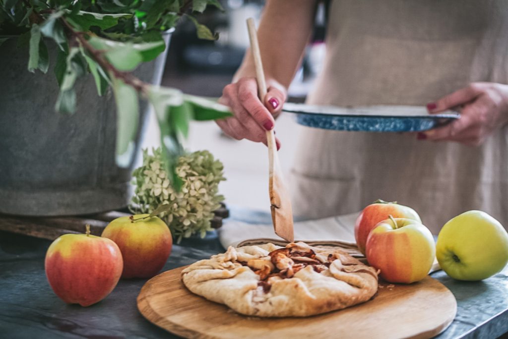 Baking a delicious apple galette with fresh apples on an antique cutting board.