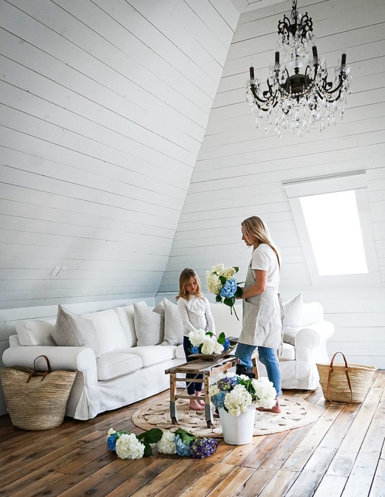 Mother and daughter arranging beautiful flowers together in a beautiful attic space.