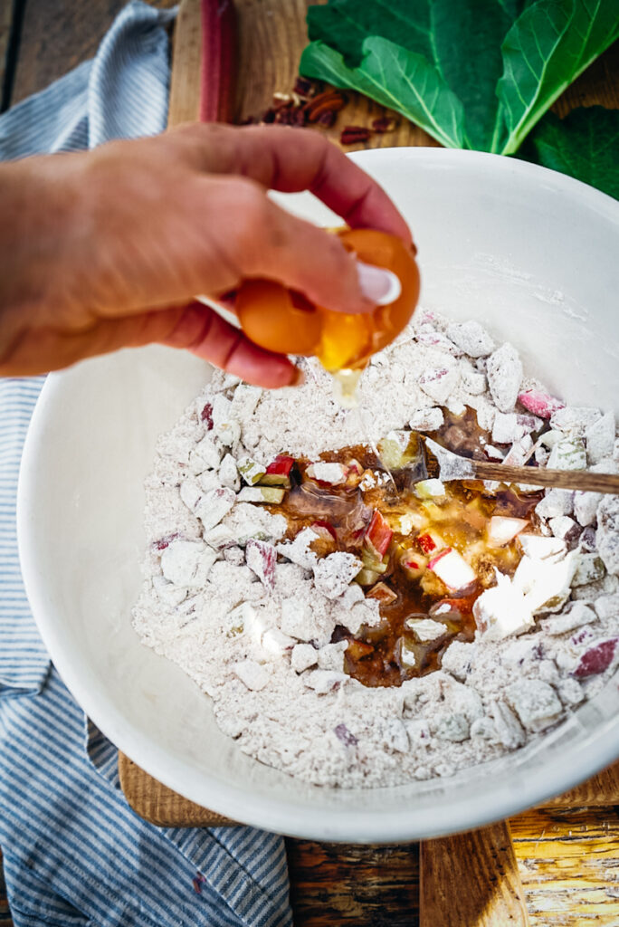 adding egg to the rhubarb bread batter.