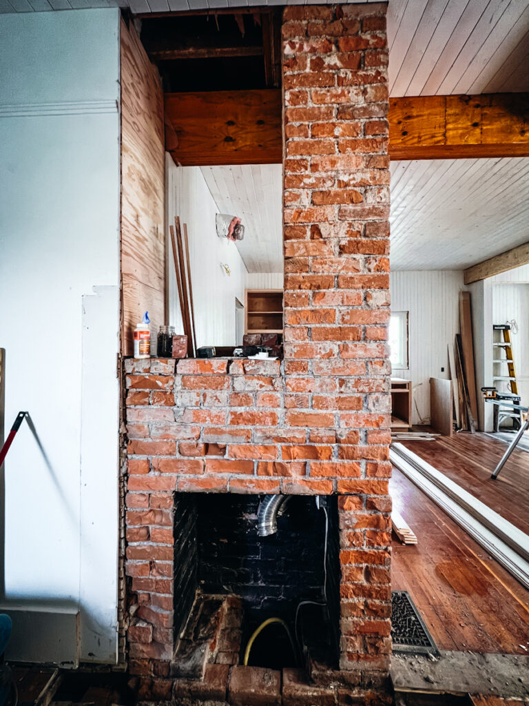 Exposed brick fireplace in an old house.