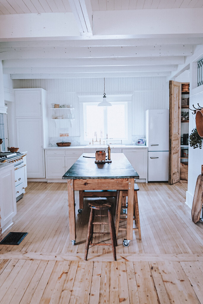 White open concept Scandiavian kitchen with clean lines and a natural wood island.