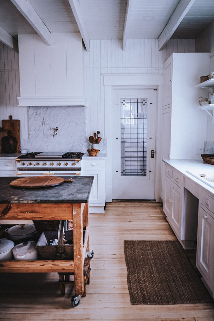 A beautiful view of a Scandinavian kitchen with a glass door and stunning Lacanche range.