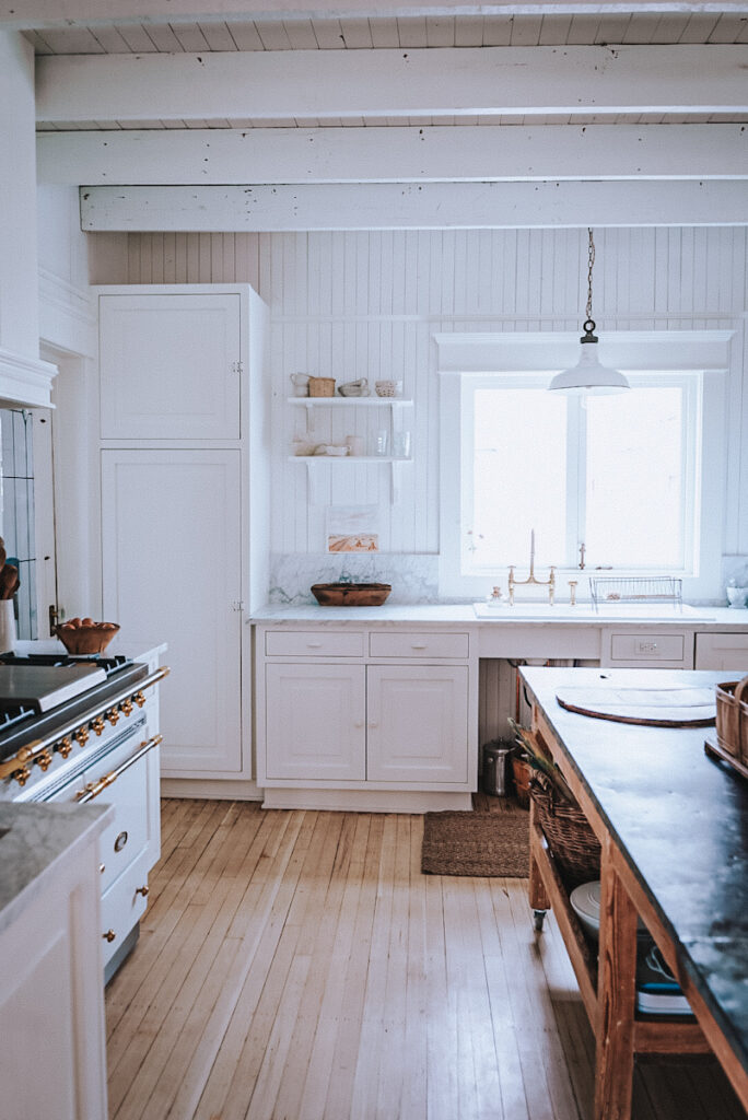 White Scandinavian kitchen with bright natural light, clean lines and wood accents. 