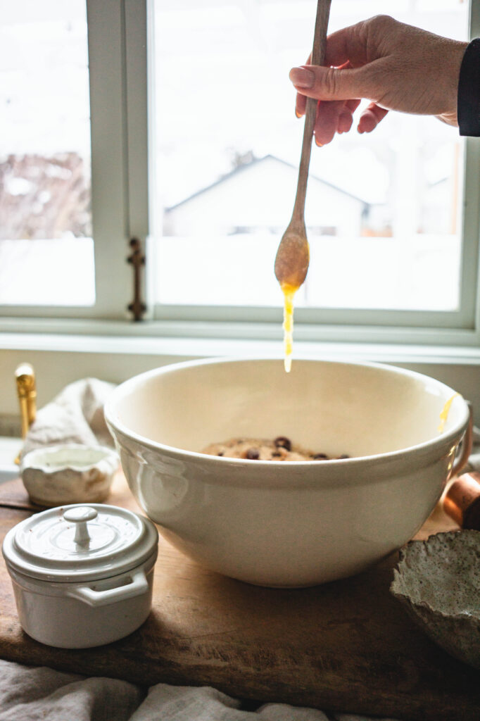 Adding honey to make sweet cranberry bread