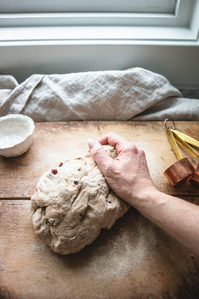 Kneading the bread on a wooden cutting board.