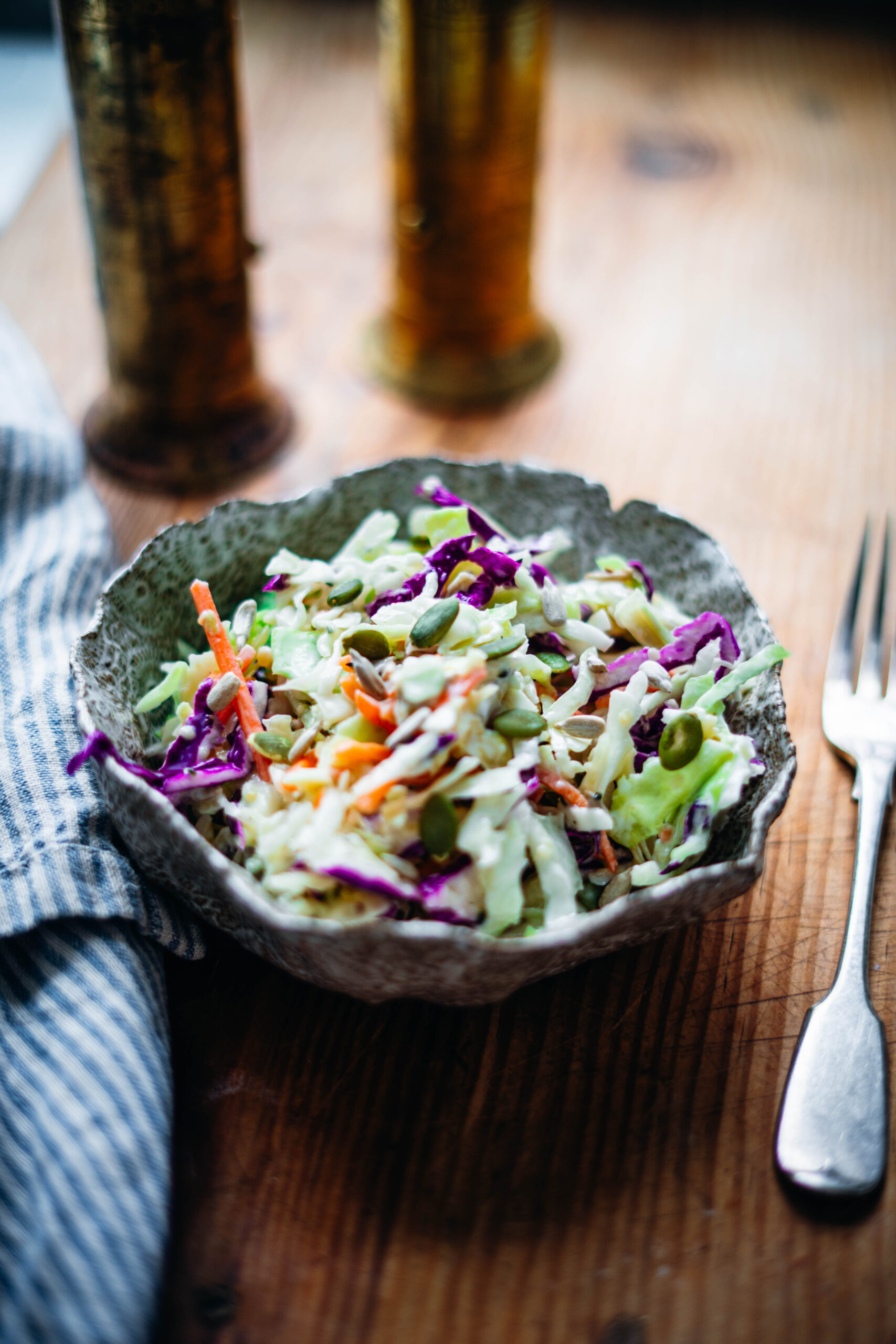 Coleslaw made with Greek yogurt, apple cider vinegar and healthy nuts in a stone bowl.