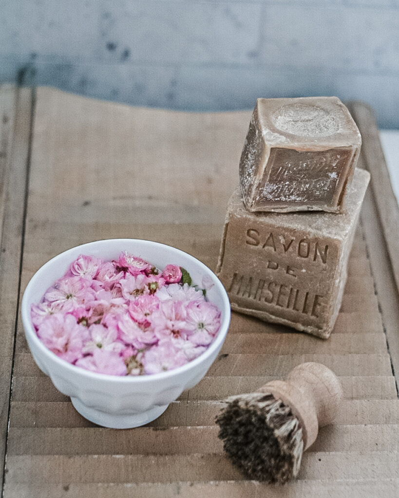 Cherry blossoms displayed as floating flowers in a stoneware bowl.