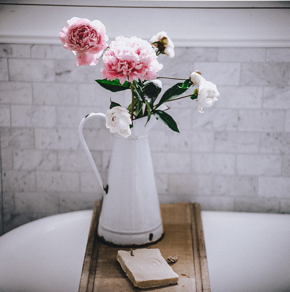 Beautiful pink and white peony arrangement in a white antique pitcher.